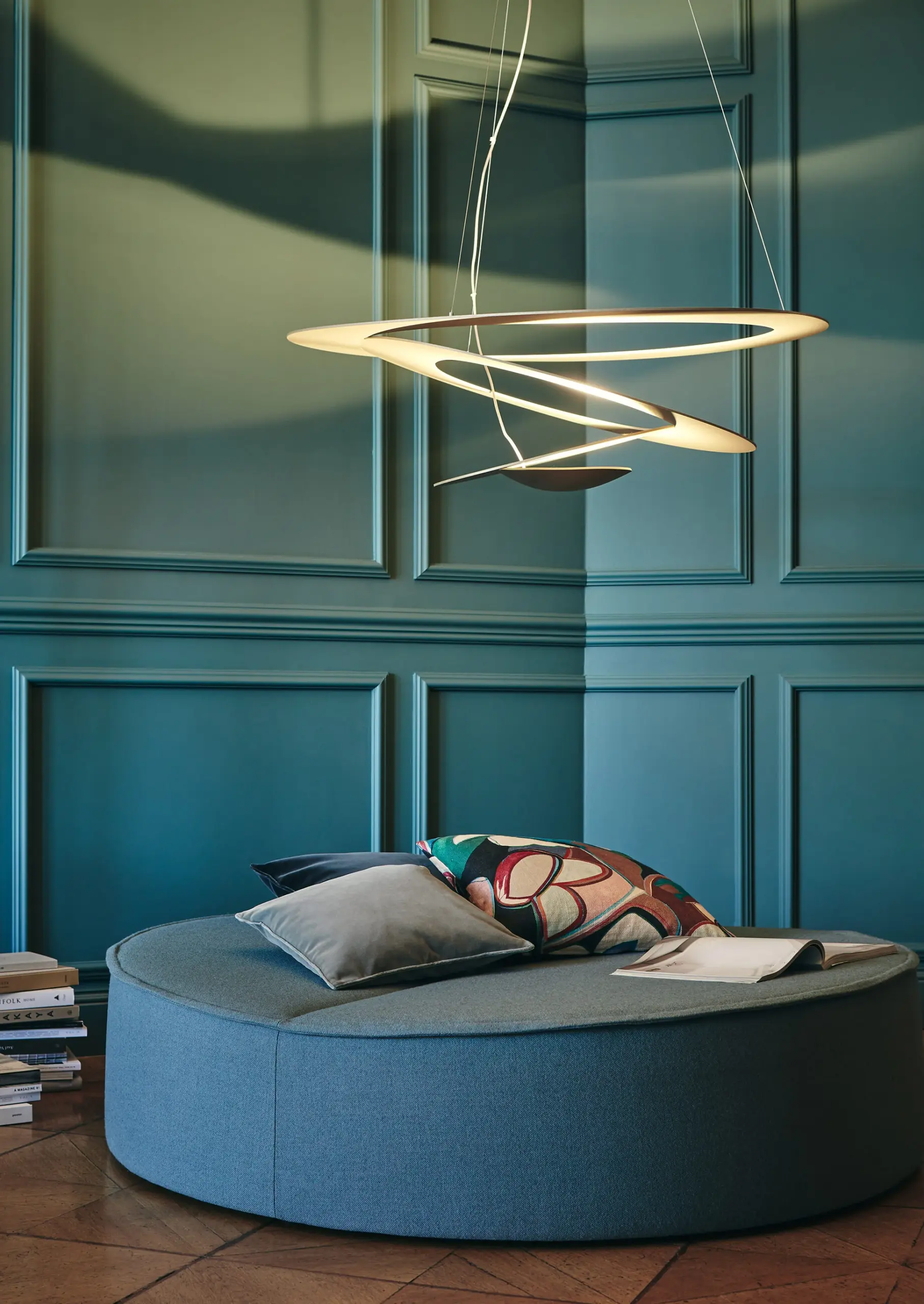 Artemide Pendelleuchte Pirce in Gold mit spiralförmigen Ringen über einer runden Sitzinsel