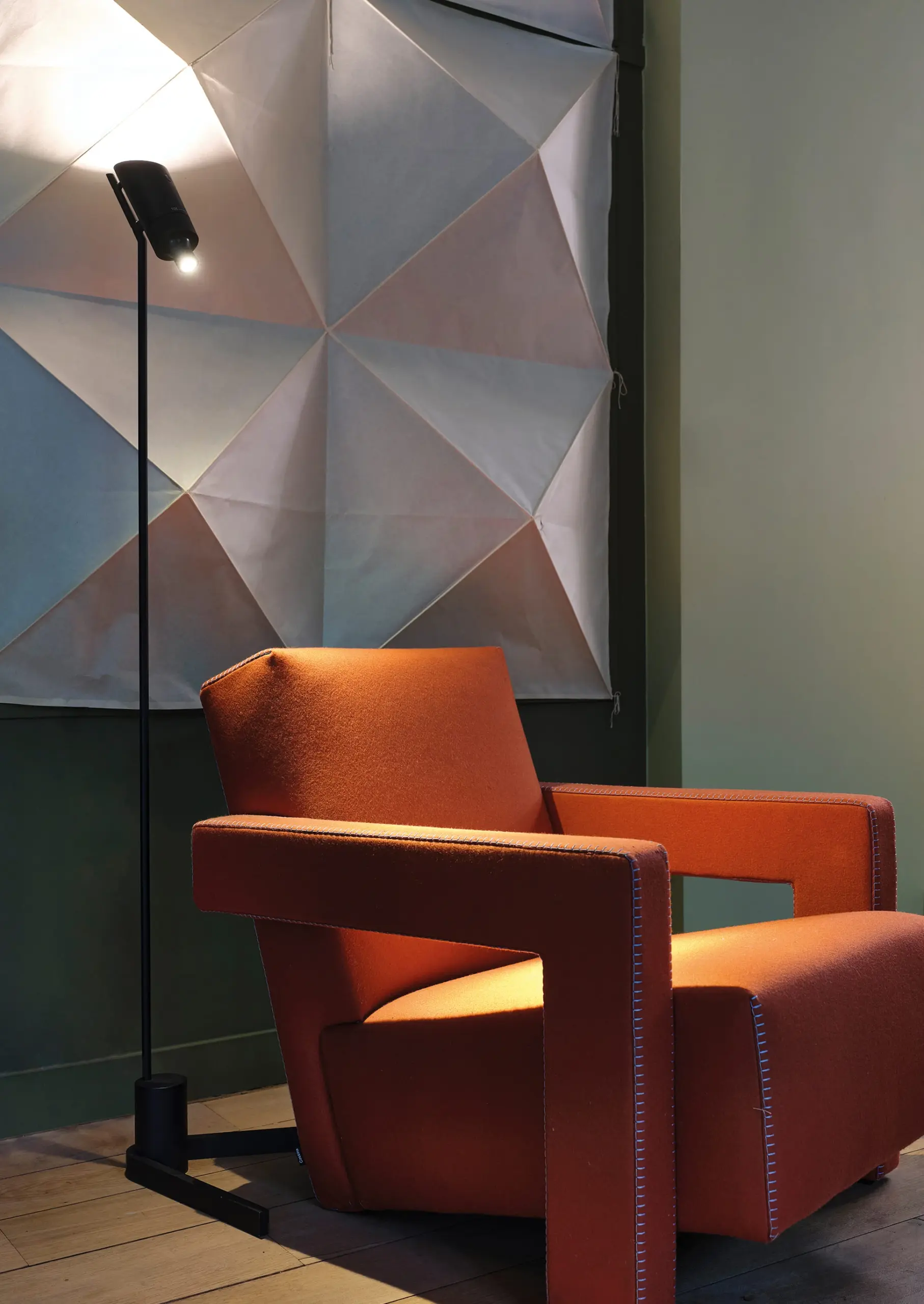 Schwarze DCW éditions Stehlampe Vision 20/20 neben einem orangefarbenen Sessel im Wohnzimmer