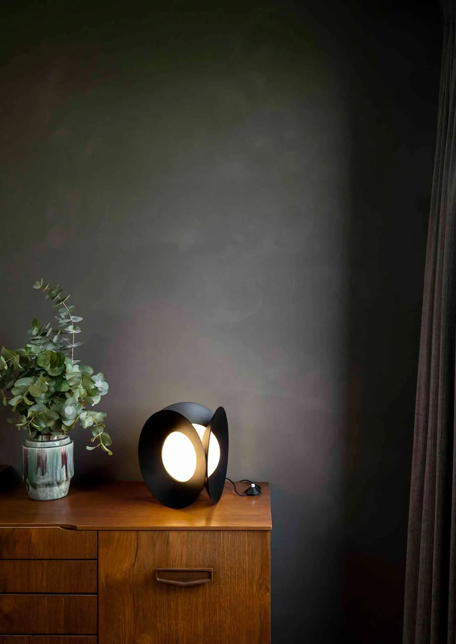 Schwarze DCW éditions Tischleuchte Armen mit schalenförmigen Reflektoren auf einer Holzkommode