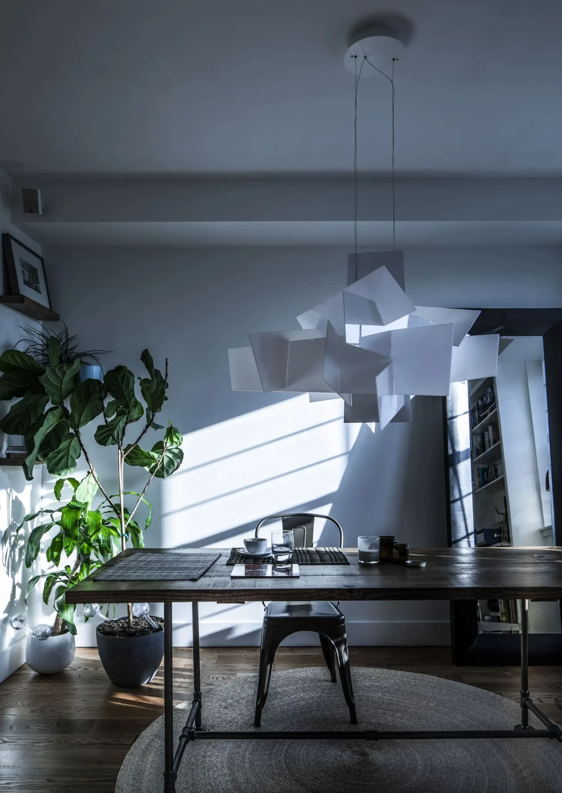 Weiße Foscarini Pendelleuchte Big Bang über einem dunklen Holztisch im Esszimmer