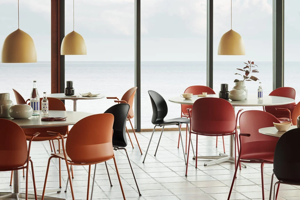 Fritz Hansen Pendelleuchten Suspence über Tischen in einem Restaurant am Meer
