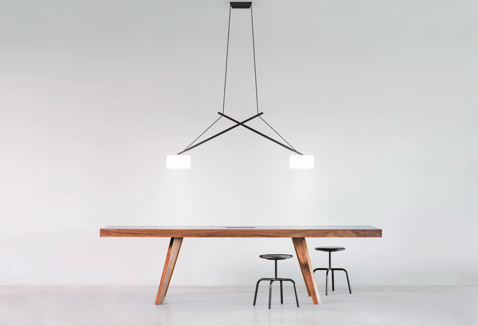 Schwarze serien.lighting Pendelleuchte Twin mit zwei Schirmen über einem Holztisch