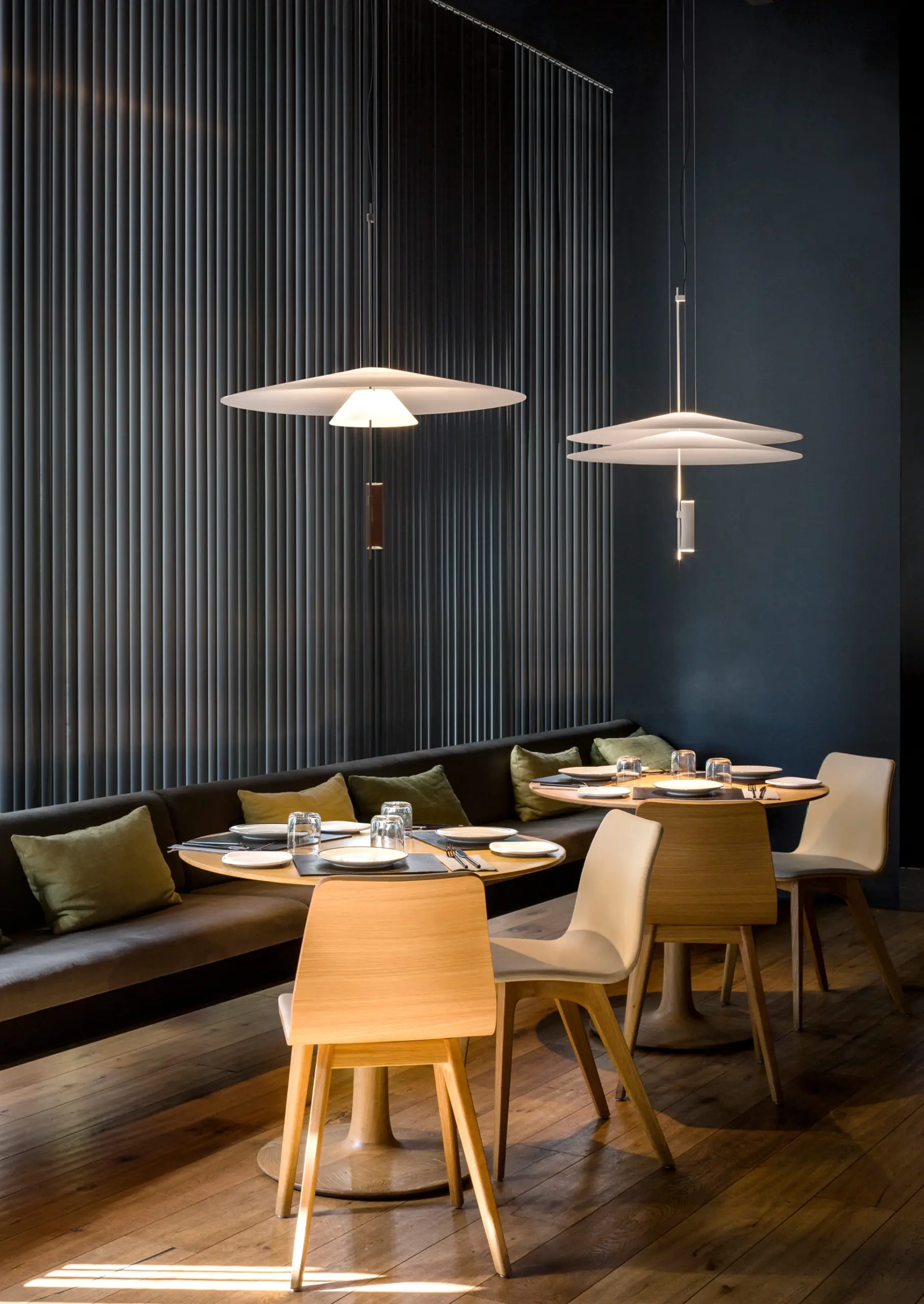 Zwei Vibia Pendelleuchten Flamingo über runden Tischen eines Restaurants