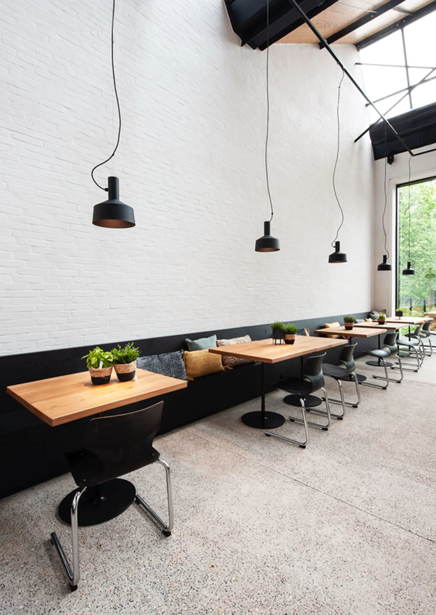 Schwarze Wever & Ducré Pendelleuchten Dinor über den Tischen eines Cafés
